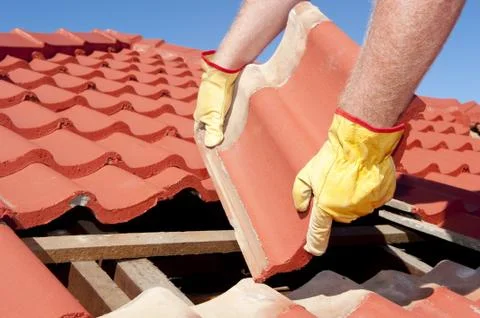 Construction worker tile roofing repairs Stock-Fotos
