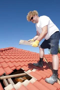 Construction worker tile roofing repairs Stock Photos