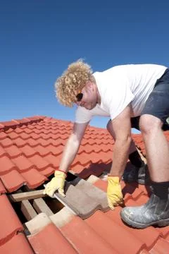 Construction worker tile roofing repairs Stock Photos