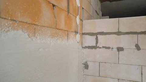 Construction worker with trowel plastering a wall. Fresh plaster on the wall  Stock Photos