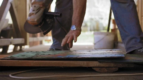 A construction worker is turning a metal sheet and is starting polishing it Stock Footage 90428709