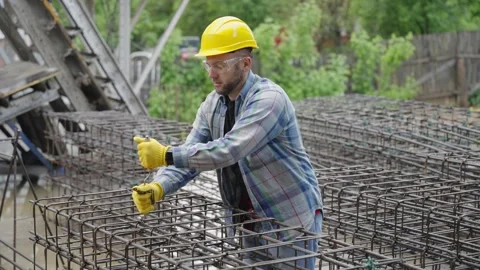 Construction worker tying rebar for concrete foundation Stock Footage 337468893