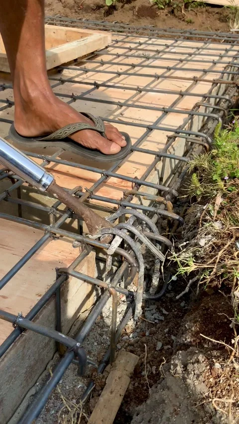 Construction worker tying steel rebar reinforcement for concrete foundation Видео 334533546
