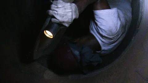 Construction worker underground climbing through pipe or tunnel Stock Footage 123721213