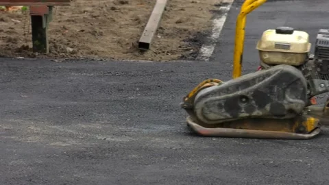 Construction worker in uniform operate vibratory plate compactor. Stock Footage 120939050