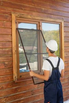 Construction worker in a uniformed changes the net to protect against mosquit Foto stock