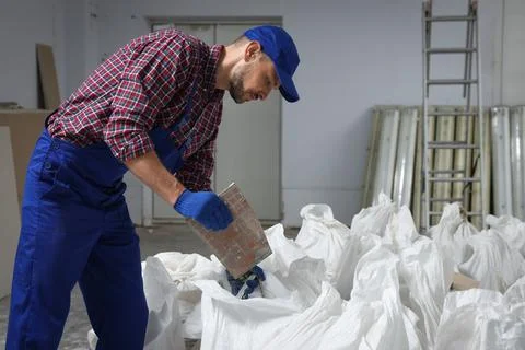 Construction worker with used building materials in room prepared for renovat Stock Photos