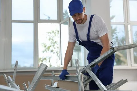Construction worker with used building materials in room prepared for renov.. Fotos de archivo