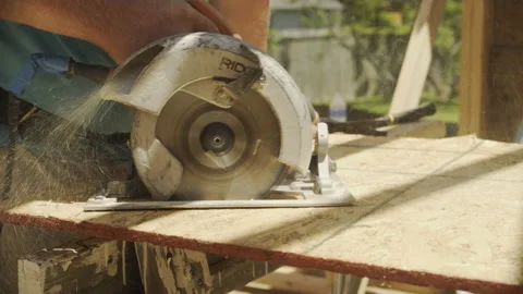Construction Worker Uses Circular Saw to Cut Plywood Sheet, Close Up Video stock 133021944