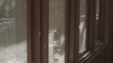 Construction worker uses a circular saw shot through a window Video stock 144294231