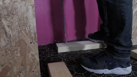 Construction worker uses drill while making a hole in a wooden platform Stock Footage 291825202