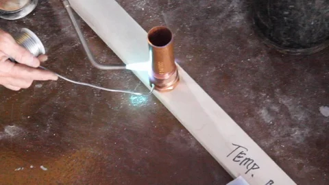 Construction worker uses electrical heat tempering on bronze metal A Stock Footage 125057047