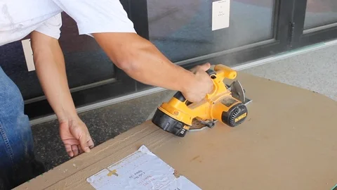 Construction worker uses hand held circular electrical saw on wood work C 스톡 동영상 125057075