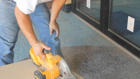 Construction worker uses hand held circular electrical saw on wood work B Stock Footage 125057080