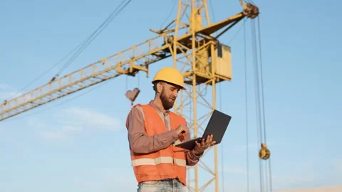 Construction worker uses laptop on site to manage project Stock Footage 311308619