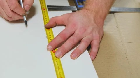 Construction worker uses measuring tape to draw precise marks Stock Footage 304401781