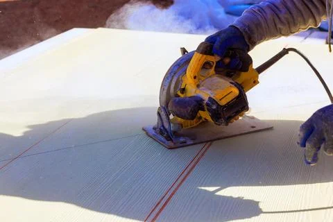Construction worker uses saw on project at job site during work progresses Stock Photos