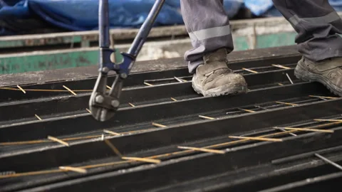 A construction worker uses specialized tools to cut rebar 動画素材 314797993