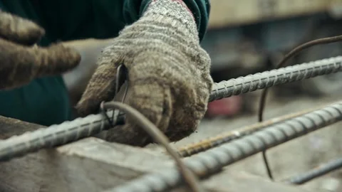 Construction worker uses steel tying wire steel rods together make steel matting Video stock 280695746