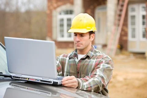 Construction: worker uses wireless computer Stock Photos
