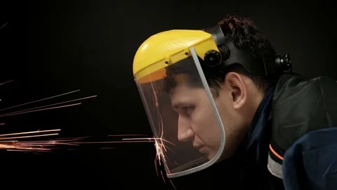 A construction worker using an angle grinder throwing sparks. Work safety Stock Footage 98997573
