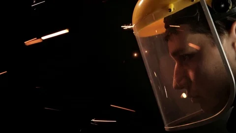 A construction worker using an angle grinder throwing sparks. Work safety Stock Footage 98997653