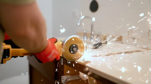 Construction worker using an angle grinder to cut a bathroom countertop during Stock Footage 332185685