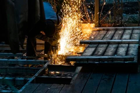 A construction worker using an angle grinder producing a lot of sparks 写真素材