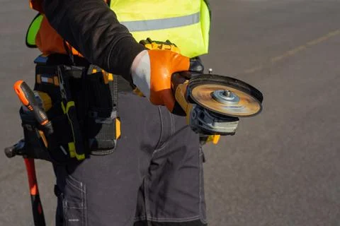 Construction worker using angle grinder power tool with rotating cutting disc Stock Photos