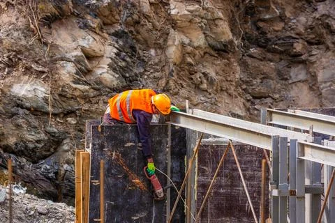 Construction Worker Using Angle Grinder at Hydroelectric Plant Stock-Fotos