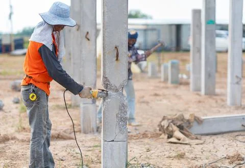 Construction worker using an angle grinder power tool to cut and score a pr.. Stock Photos