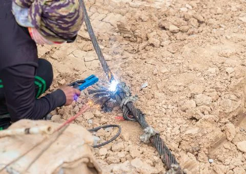 Construction worker using an arc welding torch to cut a heavy-duty steel wi.. Stock Photos