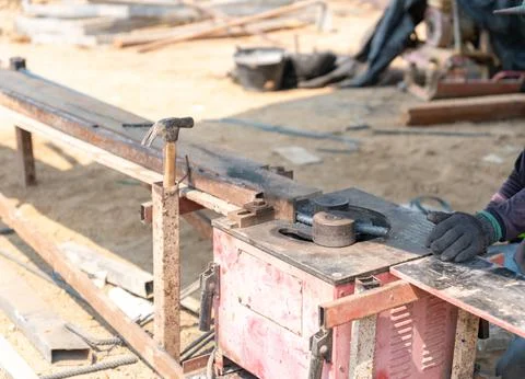 Construction worker using an automatic rebar bending machine to shape steel.. Stock Photos