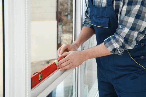 Construction worker using bubble level while installing window indoors, close 스톡 사진