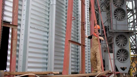 Construction Worker Using Chain Hoist in Silo Building. Stock Footage 271630286