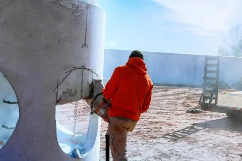 Construction worker using a chainsaw for cutting through a concrete structu.. Stock Photos