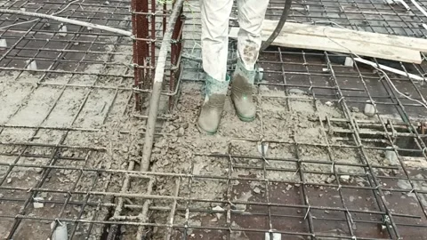 Construction worker using a concrete vibrator on a reinforced steel Vidéo 332883525