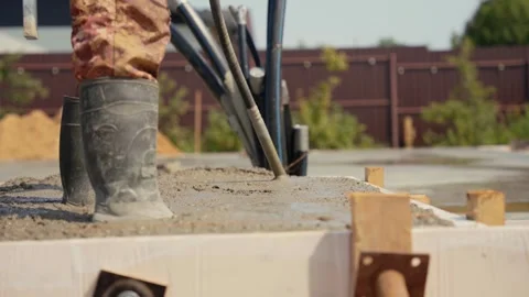 Construction worker using concrete vibrator on foundation Stock Footage 341294549