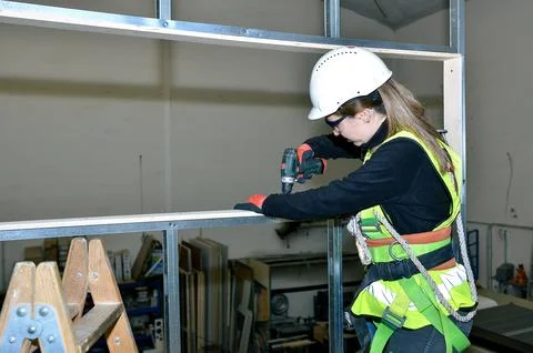 Construction worker using cordless screwdriver, mounting plasterboard on me.. Stock Photos