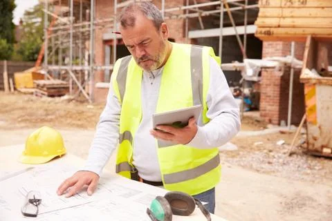 Construction Worker Using Digital Tablet On Building Site Stock Photos