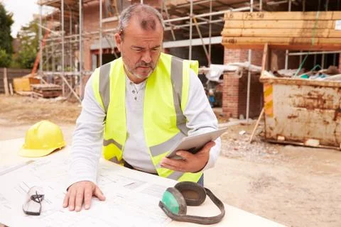 Construction Worker Using Digital Tablet On Building Site Stock Photos