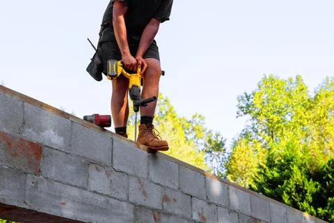 Construction worker using drill on concrete wall at job site Stock Photos