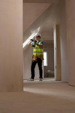Construction Worker Using Drill To Install Replacement Window Stock Photos
