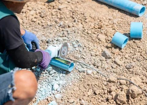 A construction worker using an electric angle grinder to precisely cut a bl.. Фото