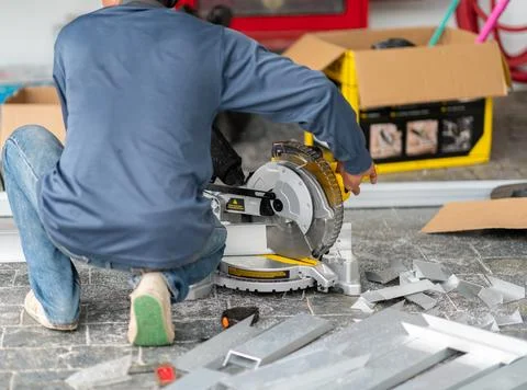 Construction worker using a electric circular miter saw to precisely cut al.. Stock Photos