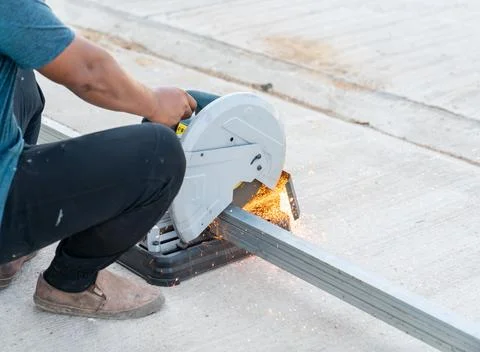 Construction worker using electric grinder cutting steel bar. Foto stock