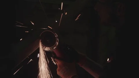 Construction worker using grinder in the dark Stock Footage 69766754
