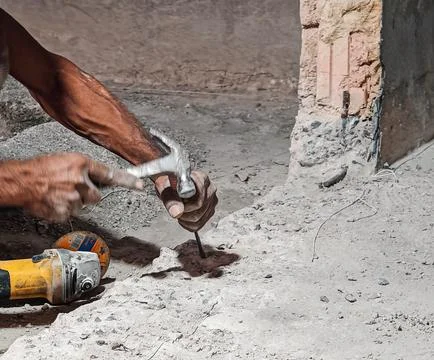 Construction Worker Using Hammer and Chisel for Concrete Repairz Stock Photos