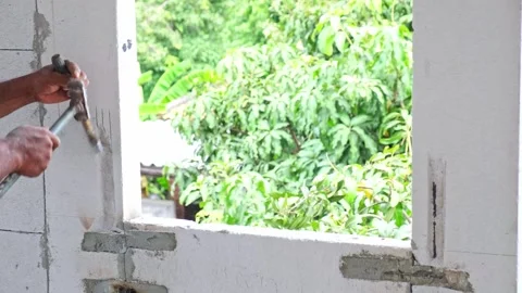 A construction worker is using a hammer to chisel grooves in lightweight br.. Stock Footage 300080270