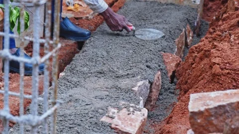 Construction worker using hand trowel tool for levelling cement mortar on Stock Footage 333412925